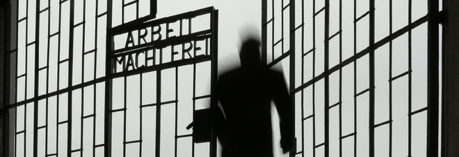 A man enters the Sachsenhausen Nazi death camp through the gate with the phrase 'Arbeit macht frei' (work sets you free) at the International Holocaust Remembrance Day, in Oranienburg, about 30 kilometers, (18 miles) north of Berlin, Wednesday, Jan. 27, 2016. The International Holocaust Remembrance Day marks the liberation of the Auschwitz Nazi death camp on Jan. 27, 1945. (AP Photo/Markus Schreiber)